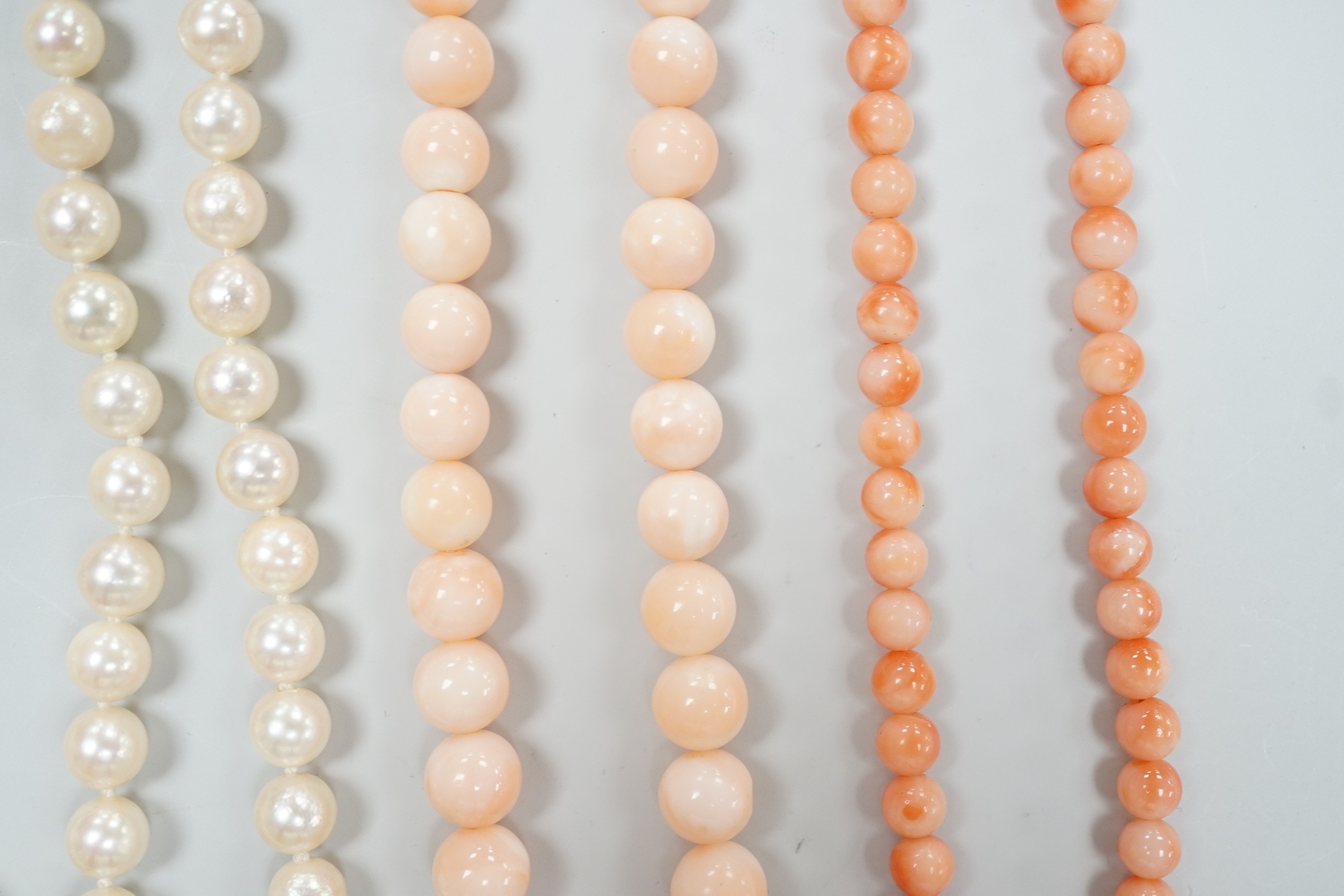 Two modern single strand cultured pearl necklaces, both with 375 clasp, one with hematite beads, longest 42cm, together with two modern coral bead necklaces, one with pair of matching drop earrings.